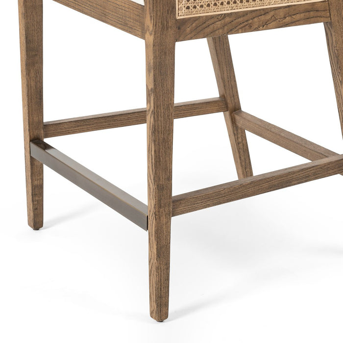 Light-toasted nettlewood frames a textural inlay of natural cane arms and back with a light, linen-blend seat of high-performance fabric counter stool shopkoehndesign calgary furniture shop amy koehn calgary designer