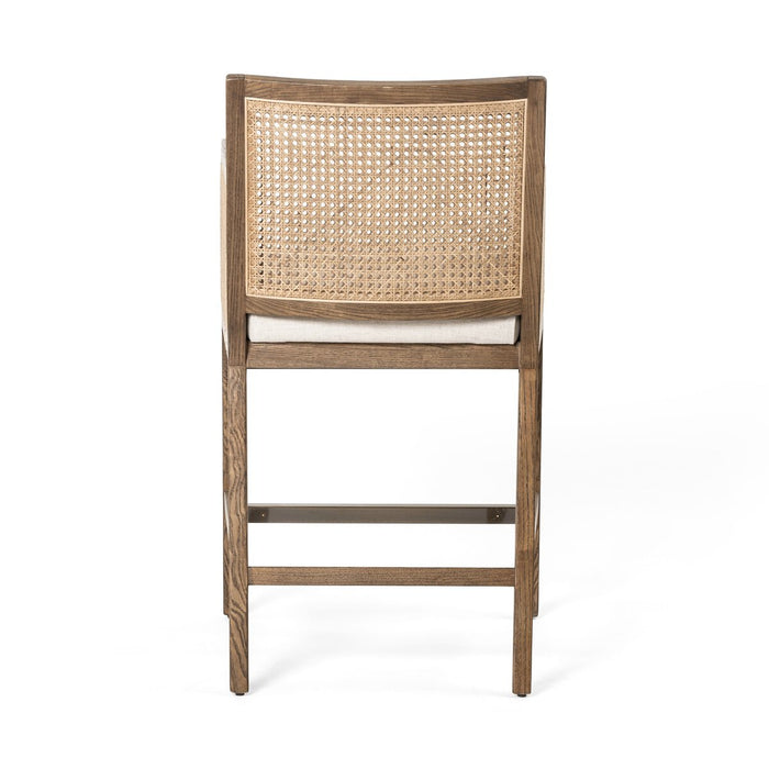 Light-toasted nettlewood frames a textural inlay of natural cane arms and back with a light, linen-blend seat of high-performance fabric counter stool shopkoehndesign calgary furniture shop amy koehn calgary designer